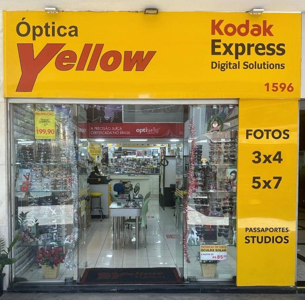 Fachada da Ótica Yellow: letreiro amarelo com Óptica Yellow e Kodak Express, número 1596 e fotos 3x4, 5x7 e passaportes